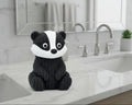 Black and white badger plush toy on a light gray background