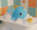 Blue plush toy with a yellow horn on a light gray background