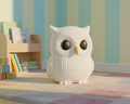 White textured owl figurine on a light blue background