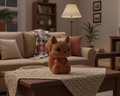 Knitted brown squirrel toy on a light gray background