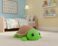 Green turtle toy with brown shell on a light gray background